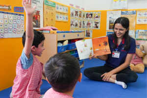 A student is rasing up his hand to answer teacher's question