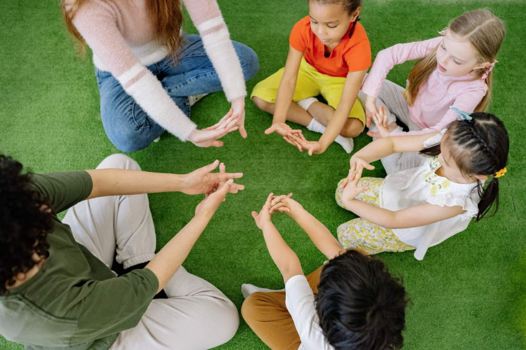 Group of children playing with their primary school teachers together